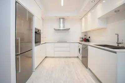 a kitchen with white cabinets and stainless steel appliances at Mayra Seafront Luxury Apartment (BREAKBOOKING-CY) in Limassol