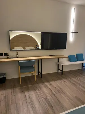 a desk with a flat screen tv and a chair at Flamingo Paradise Beach Hotel - Adults Only in Protaras