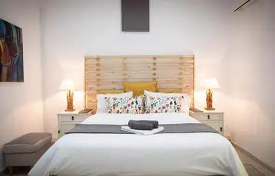 a bedroom with a large white bed with two lamps at LIMASSOL AKROTIRI BEACH VINE COTTAGE a in Limassol