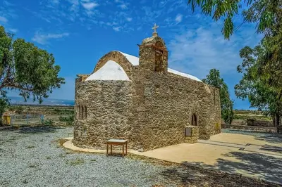 an old stone church with a bench in front of it at LIMASSOL AKROTIRI BEACH VINE COTTAGE a in Limassol