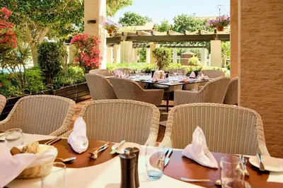 a restaurant with tables and chairs on a patio at ROBINSON Cyprus in Alaminos