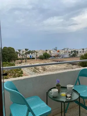 a table and chairs on a balcony with a view at Larnaca Comfort Rooms With Smart TV & Netflix in Larnaka