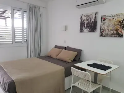 a bedroom with a bed and a table with chairs at Yialos Holiday Apartments in Pervolia