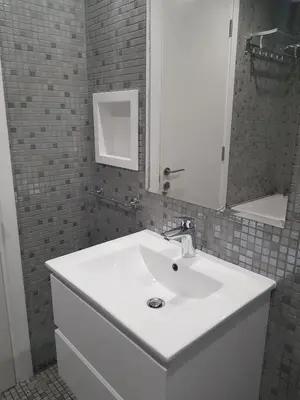 a bathroom with a white sink and a mirror at Yialos Holiday Apartments in Pervolia