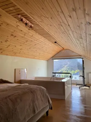 a bedroom with a bed and a tub and a window at Aprosmeno Jacuzzi House 2 in Agros