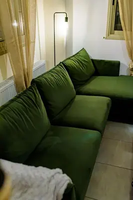 a green couch sitting in a living room at Aprosmeno Jacuzzi House 2 in Agros