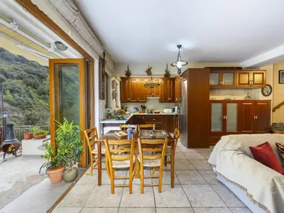 a kitchen and living room with a table and chairs at Troodos Riverside Cottage in Kato Amiandos