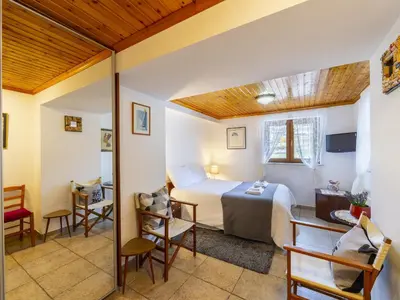 a bedroom with a bed and a table and chairs at Troodos Riverside Cottage in Kato Amiandos