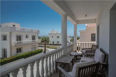 a balcony with chairs and tables and a view of a building at Carilisto Villas Big 4 Bedrooms in Center of Ayia Napa in Ayia Napa
