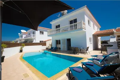a villa with a swimming pool in front of a house at Carilisto Villas Big 4 Bedrooms in Center of Ayia Napa in Ayia Napa