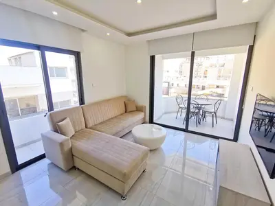 a living room with a couch and a table at Vasilo Court Seaview City Apartment in Larnaka