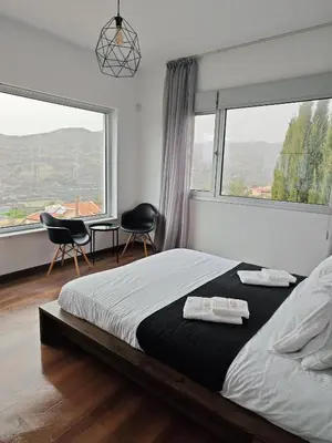 a bedroom with a bed and two chairs and windows at Maximos Luxury Villa Monagri Limassol in Limassol