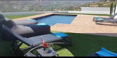 a pool with a chair and a bottle of wine next to it at Maximos Luxury Villa Monagri Limassol in Limassol