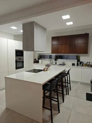 a kitchen with a large white island with bar stools at Maximos Luxury Villa Monagri Limassol in Limassol