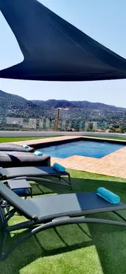 a group of lounge chairs sitting next to a swimming pool at Maximos Luxury Villa Monagri Limassol in Limassol