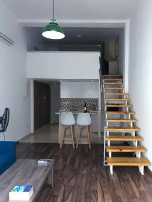a living room with a staircase and a kitchen at Cozy Loft Apartment in Ayia Napa