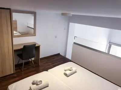 a bedroom with a bed and a desk and a chair at Cozy Loft Apartment in Ayia Napa