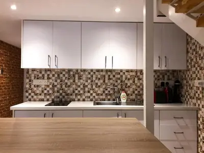 a kitchen with white cabinets and a counter top at Cozy Loft Apartment in Ayia Napa