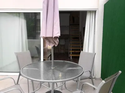 a table in a room with chairs and a pink towel at Cozy Loft Apartment 2 in Ayia Napa