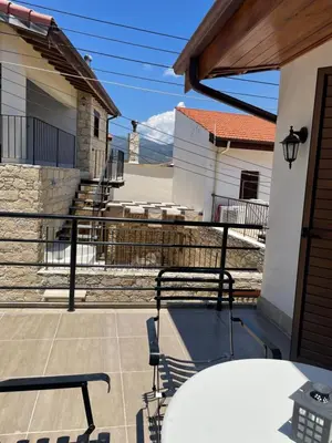 a patio with a table and chairs on a balcony at Omodos Katoi Holiday Homes in Omodos