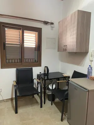 a kitchen with a table and two chairs and a table and a counter at Omodos Katoi Holiday Homes in Omodos