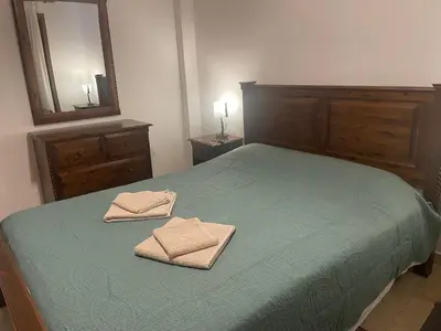 a bedroom with a green bed with two towels on it at Omodos Katoi Holiday Homes in Omodos
