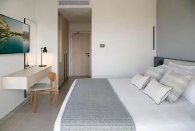 a bedroom with a white bed and a desk at Atlantica Aqua Blue in Protaras