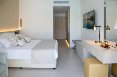 a bedroom with a white bed and a desk at Atlantica Aqua Blue in Protaras