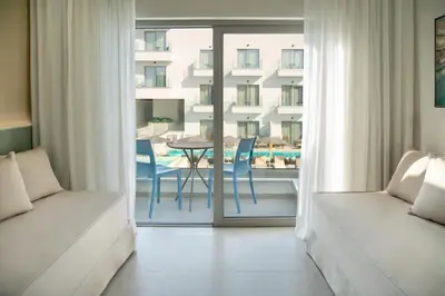 a living room with a couch and a balcony with a table at Atlantica Aqua Blue in Protaras