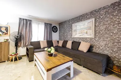 a living room with a couch and a brick wall at Pinecone Platres - 3 Units in Platres