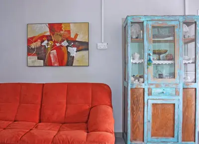 a living room with a red couch and a painting at Laoni Guest House in Moutoullas, Marathasa in Limassol