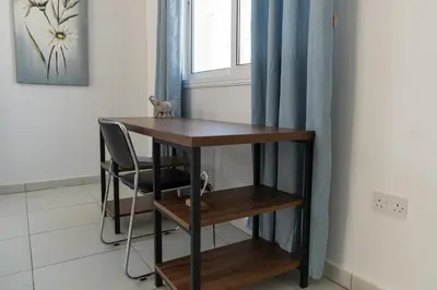 a table and a chair in a room with a window at Dafni Villa Ekaterina 3 bdrm in Protaras