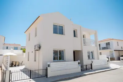 a white house with a fence in front of it at Dafni Villa Ekaterina 3 bdrm in Protaras