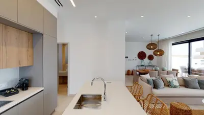 a kitchen and a living room with a couch at Periyiali Konnos Villas Beach Resort in Protaras