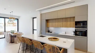 a kitchen with a large white island with chairs at Periyiali Konnos Villas Beach Resort in Protaras
