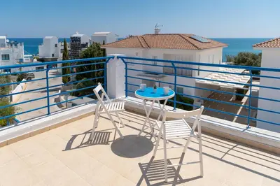 two chairs and a table on a balcony with the ocean at St Nicolaos Villa Ekaterina 3 bdrm in Protaras