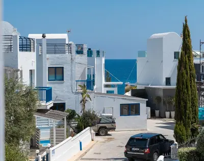 a car parked in a parking lot in front of buildings at St Nicolaos Villa Ekaterina 3 bdrm in Protaras