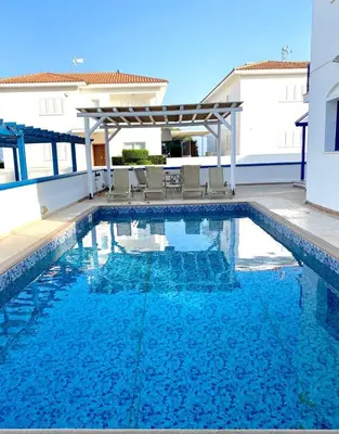 a swimming pool in a villa with blue water at St Nicolaos Villa Ekaterina 3 bdrm in Protaras