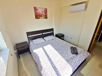 a bedroom with a bed with a pair of shoes on it at License to Chill Apartment in Larnaka