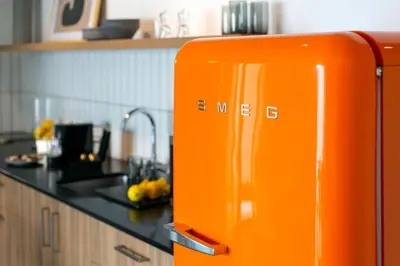 an orange refrigerator in a kitchen next to a sink at LIV URBAN Suites in Larnaka