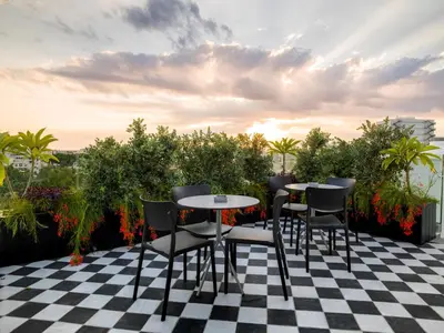 a patio with tables and chairs on a checkered floor at LIV URBAN Suites in Larnaka