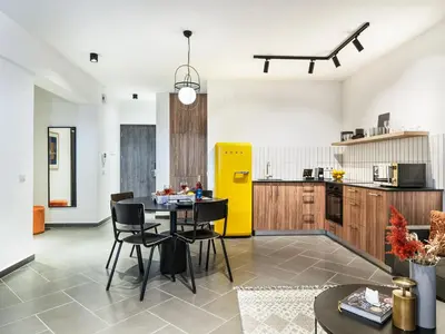 a kitchen with a table and chairs and a yellow refrigerator at LIV URBAN Suites in Larnaka