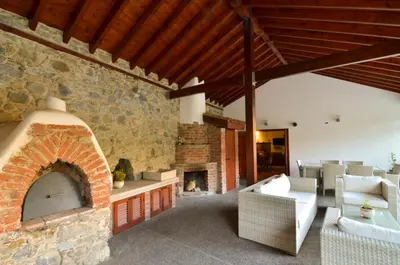 a living room with a stone fireplace and chairs at To Kastri in Kalopanayiotis