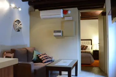a living room with a couch and a air conditioner at To Kastri in Kalopanayiotis