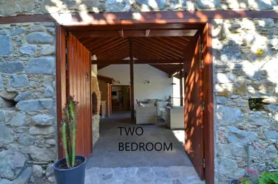 a stone building with a wooden door with the words two bedroom at To Kastri in Kalopanayiotis