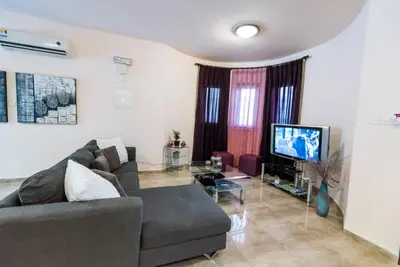 a living room with a couch and a tv at Luxury Villa Regina in Protaras
