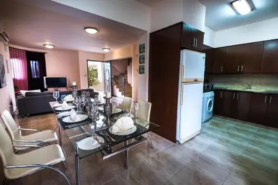 a dining room and kitchen with a table and chairs at Luxury Villa Regina in Protaras