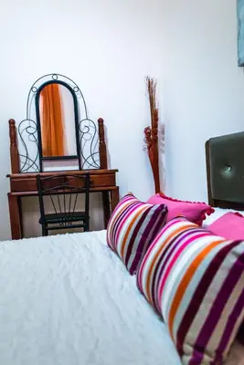 a bed with two pillows and a mirror on a table at Luxury Villa Regina in Protaras