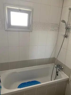 a bathroom with a bath tub with a window at Milky in Limassol