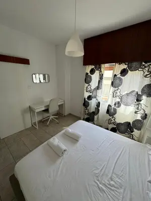 a bedroom with a large white bed and a desk at Milky in Limassol